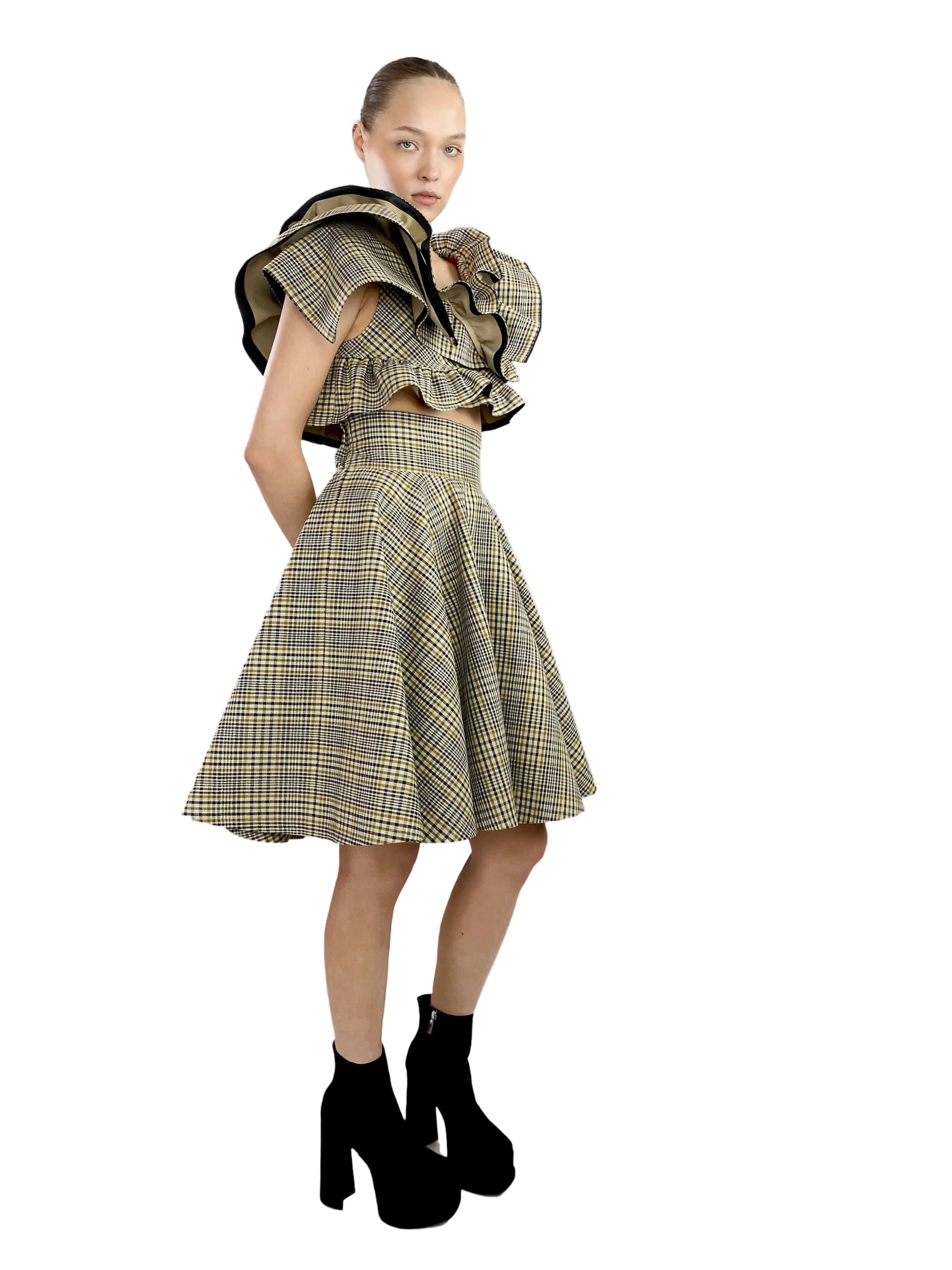 Model wearing a plaid dress with ruffled top on a white background