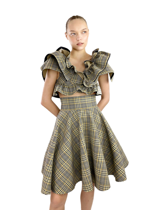 Woman wearing a plaid dress with ruffled top on a white background