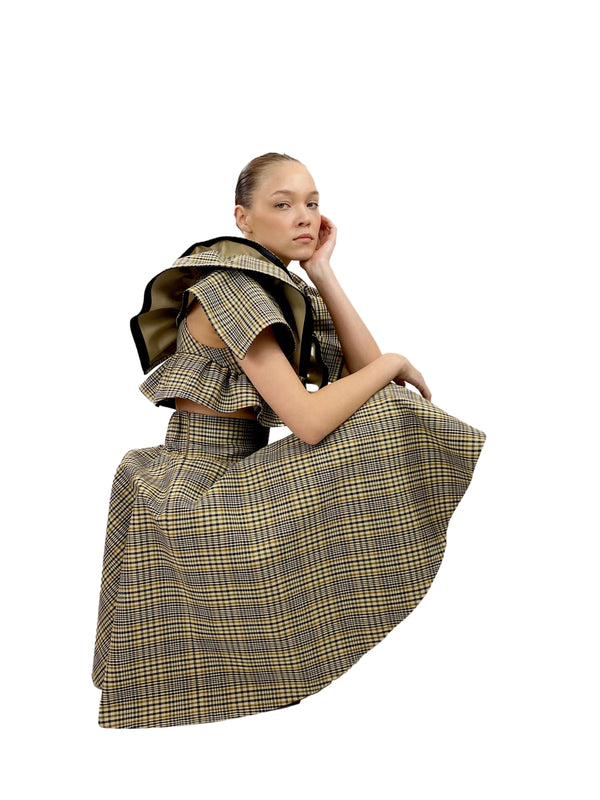 Model wearing a plaid dress with ruffled details on a white background