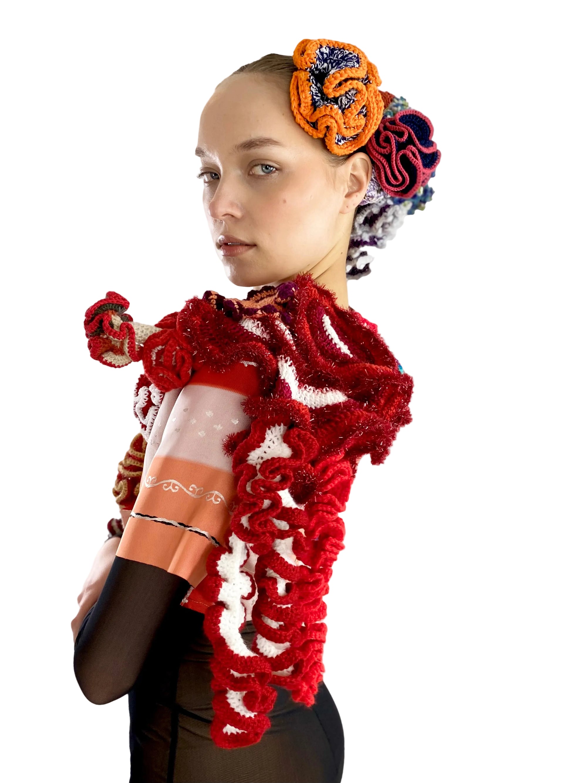 Person wearing a red textured garment with floral headpiece on a white background