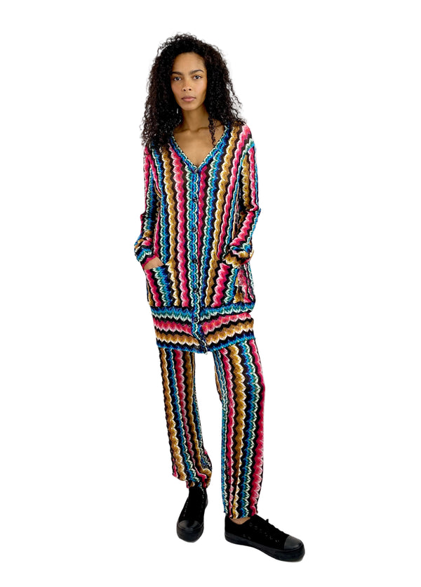 Person wearing a colorful knitted outfit on a white background