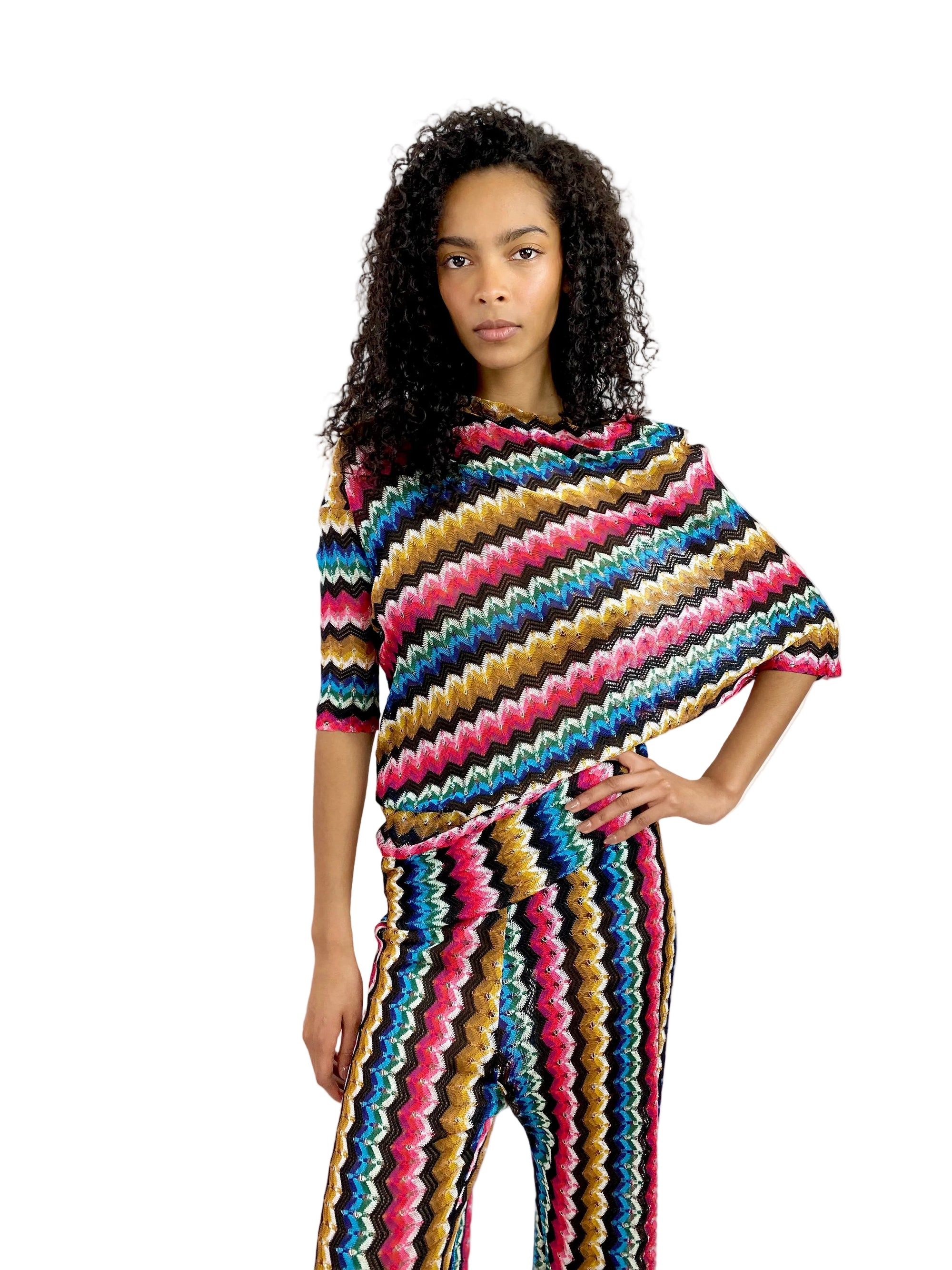 Woman wearing a colorful striped poncho against a white background