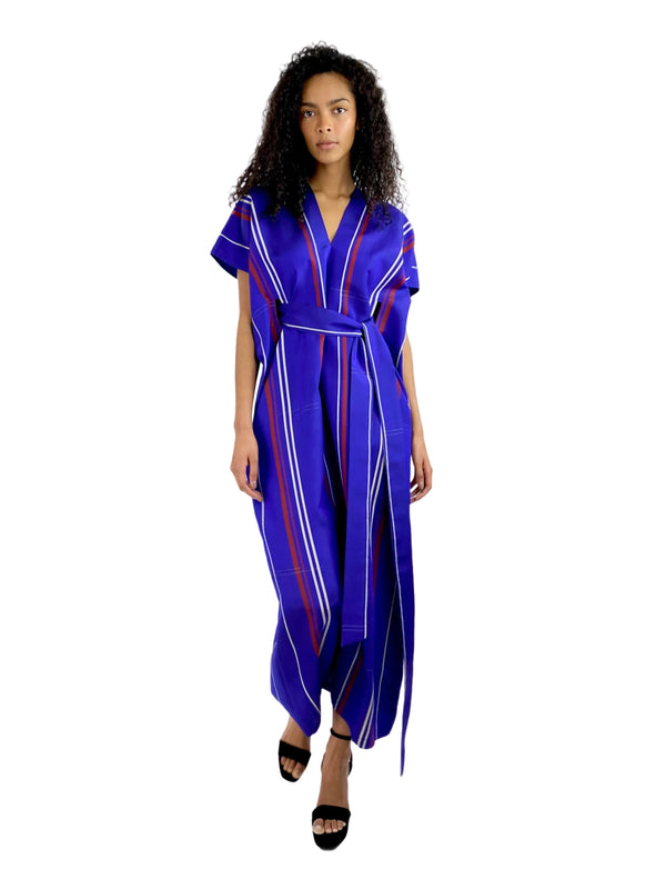 Woman wearing a blue jumpsuit with red stripes on a white background