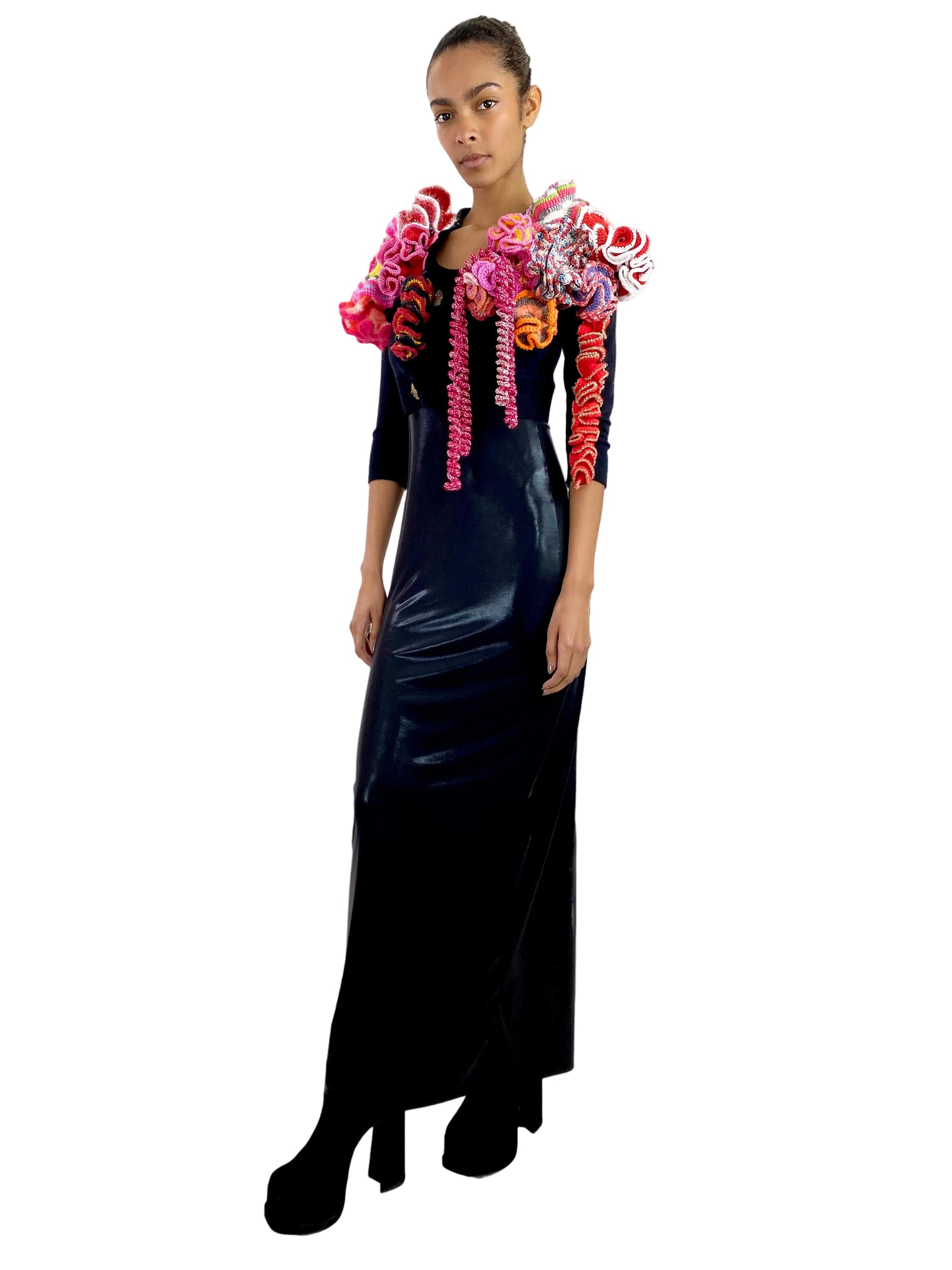 Woman wearing a black dress with colorful floral accents on a white background