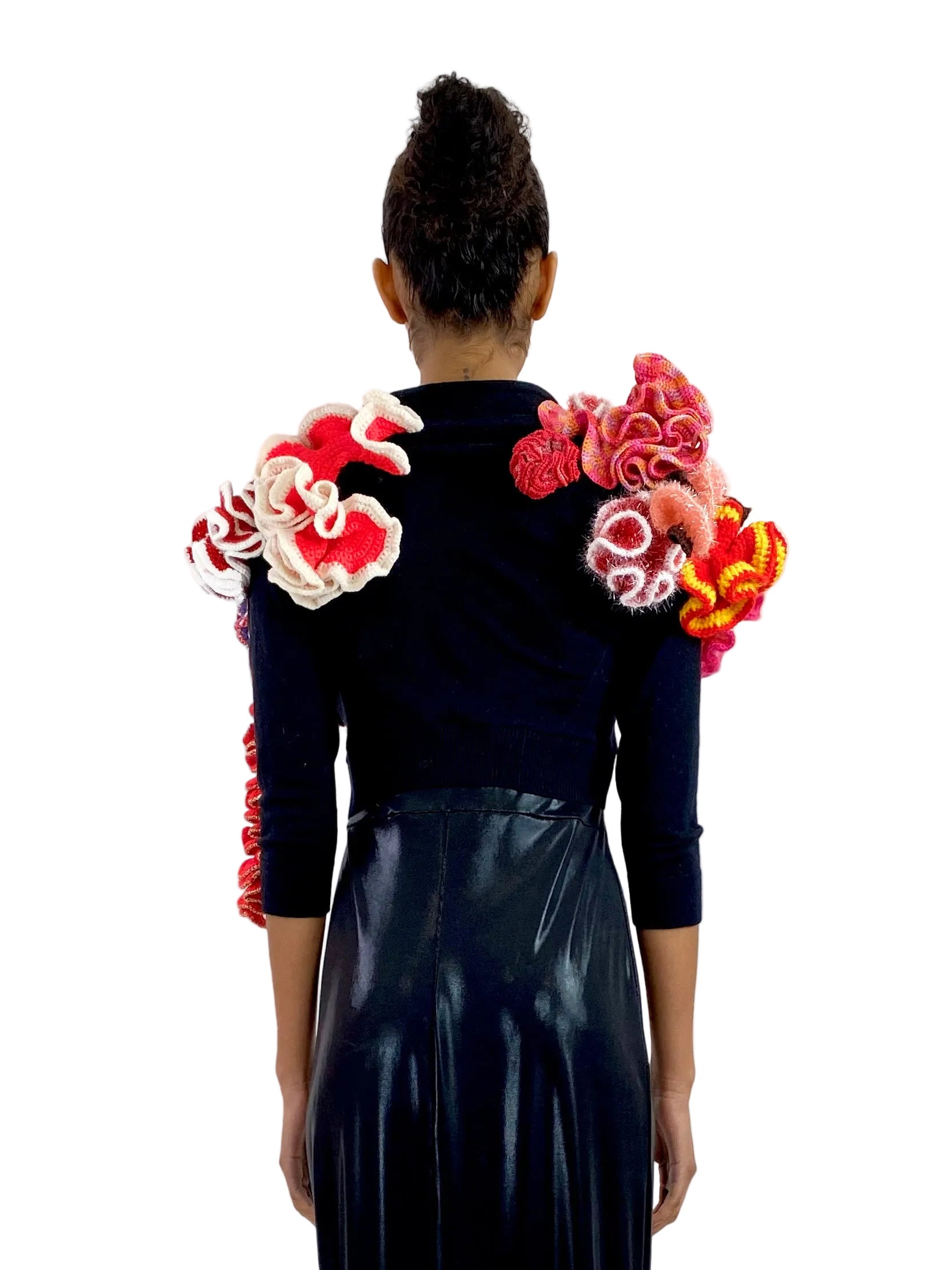 Person wearing a black outfit with colorful floral designs on the back against a white background