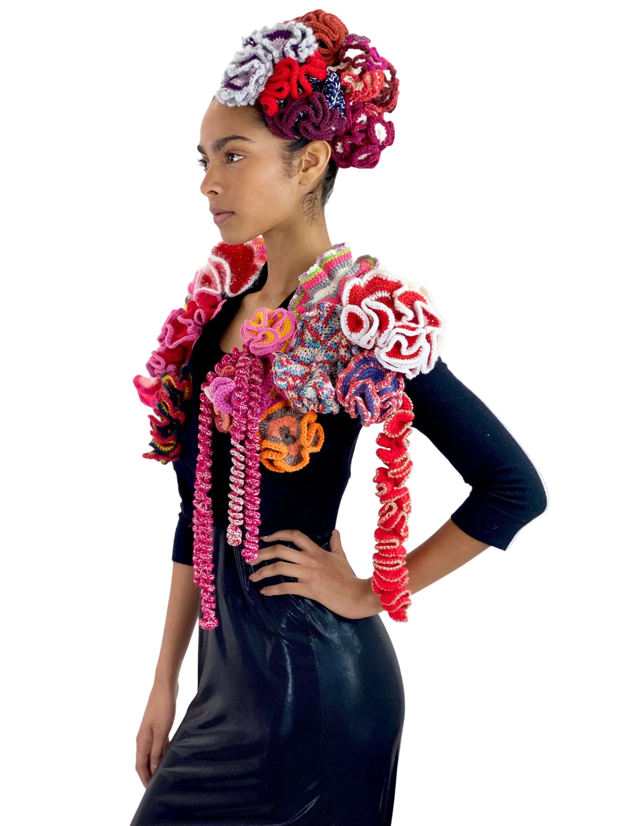 Woman wearing a colorful floral headpiece and scarf on a white background